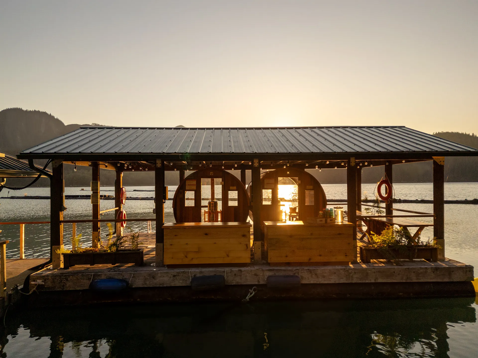 The floatplane dock and its shelter at sunset from the drone, the cove flat and gold