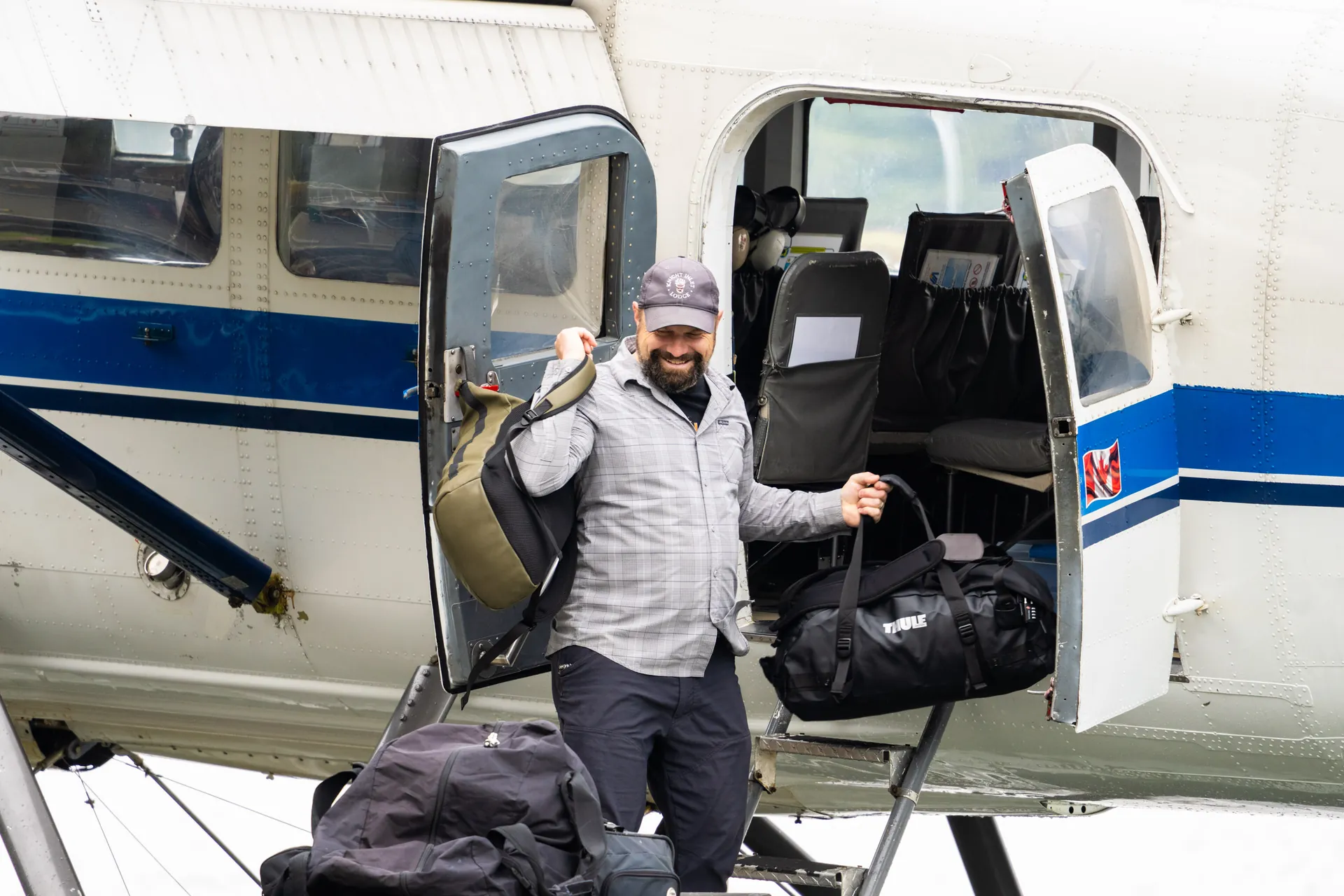 The pilot loading bags through the floatplane door