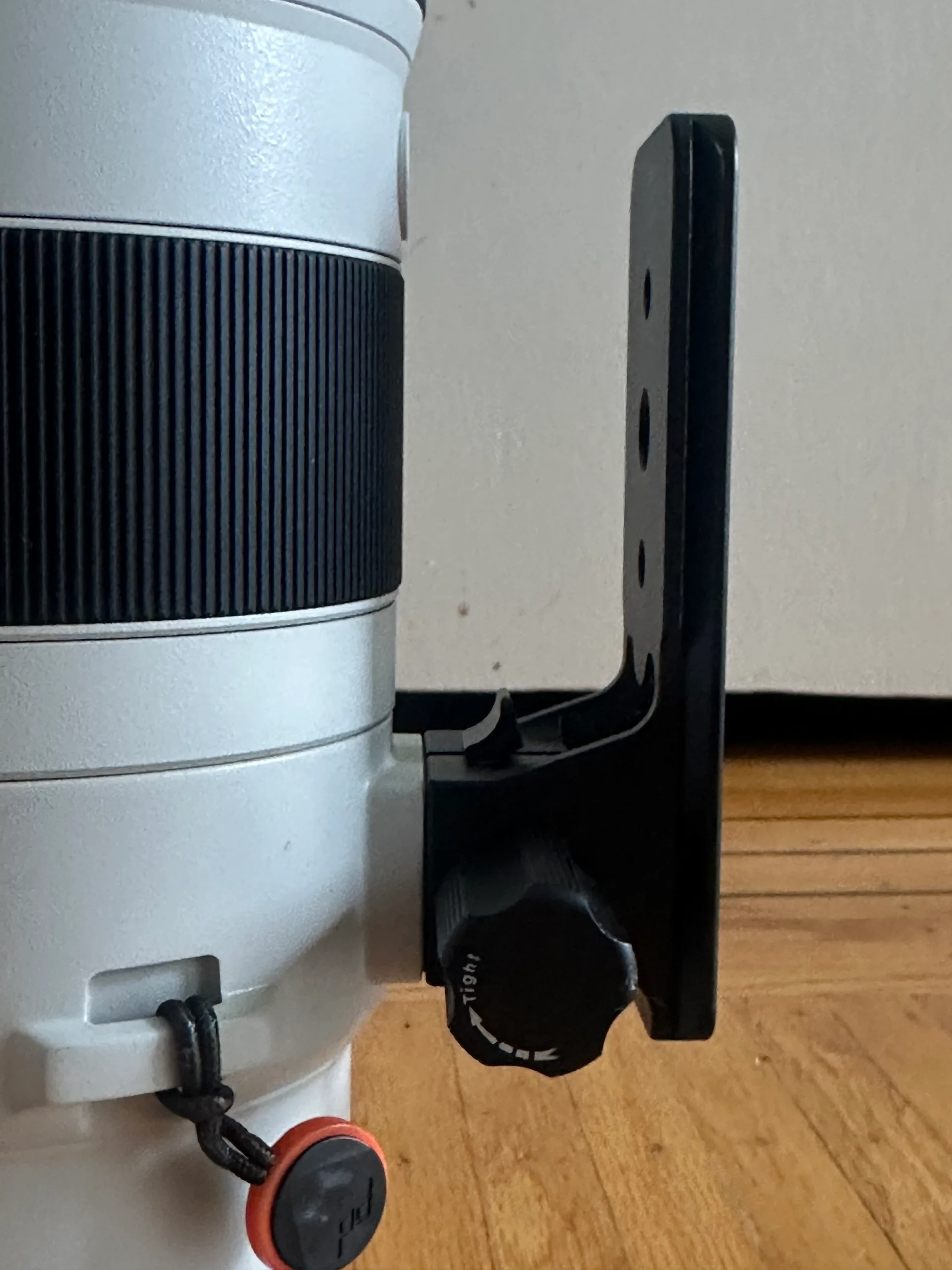 The iShoot Arca-Swiss replacement foot fitted to the collar of the white Sony 200-600, its locking knob and dovetail plate visible