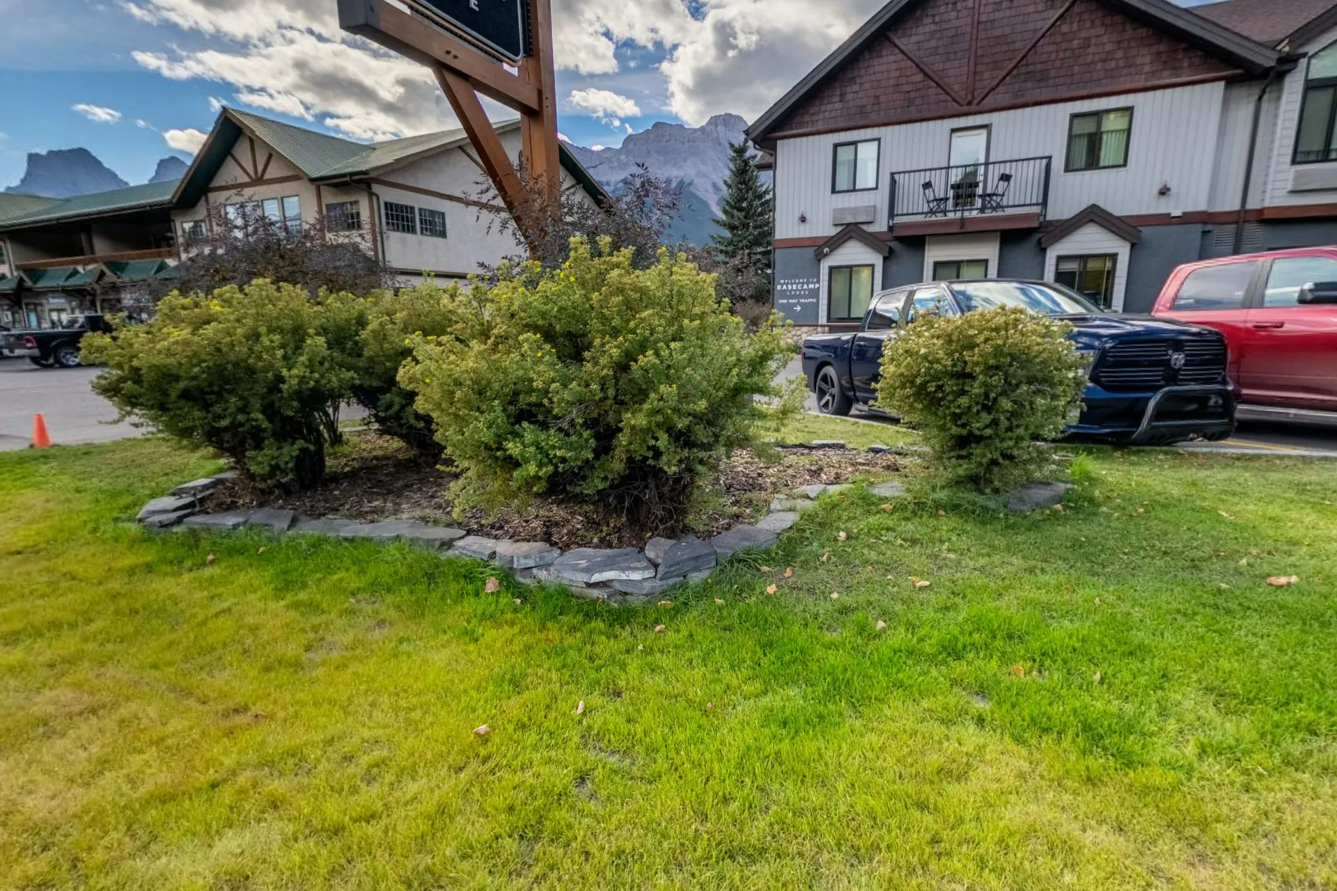 The lodge from the street, shrubs and lawn in front and the peaks above the rooflines
