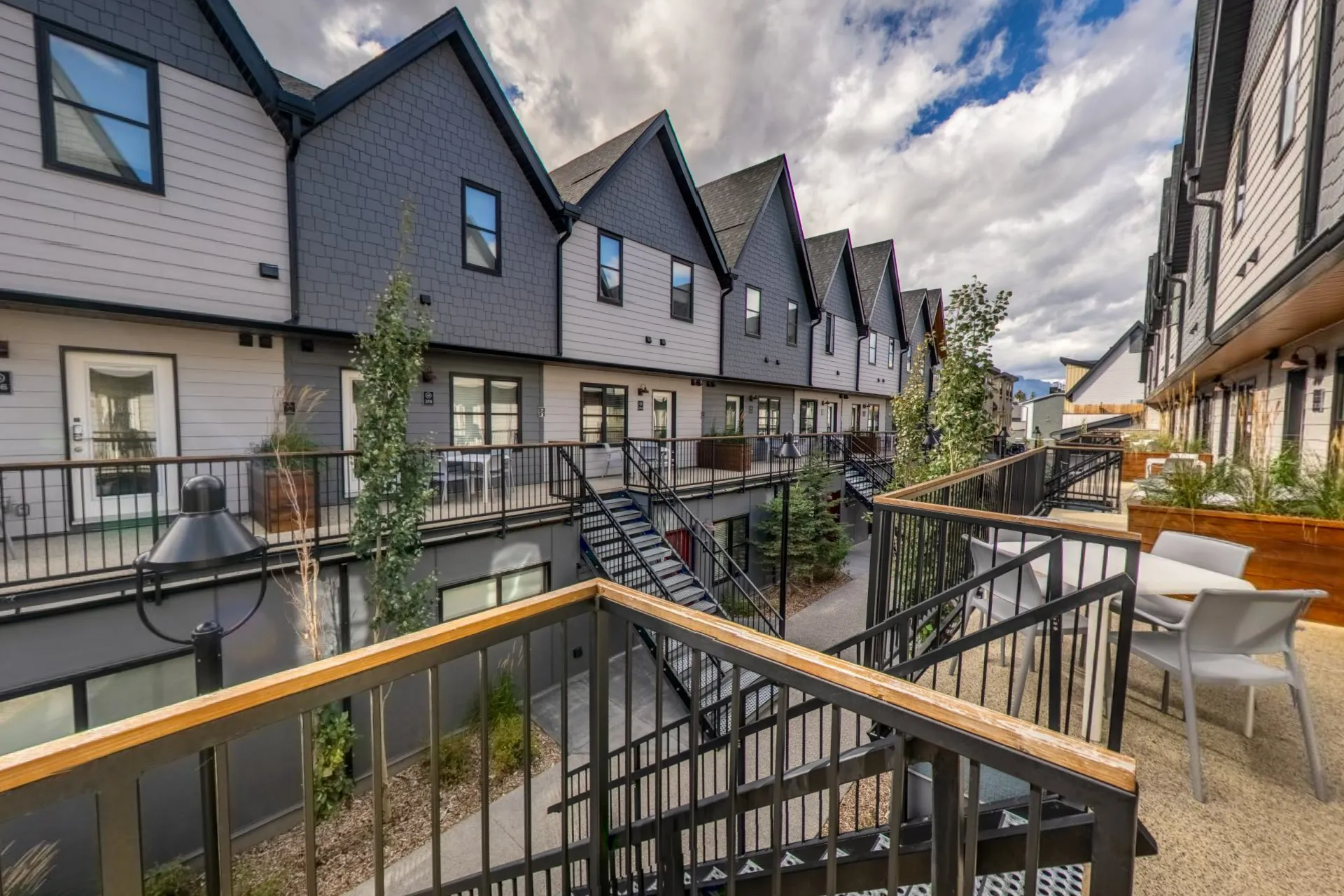 The courtyard walkway between the gabled townhouse suites, patio furniture on the upper decks
