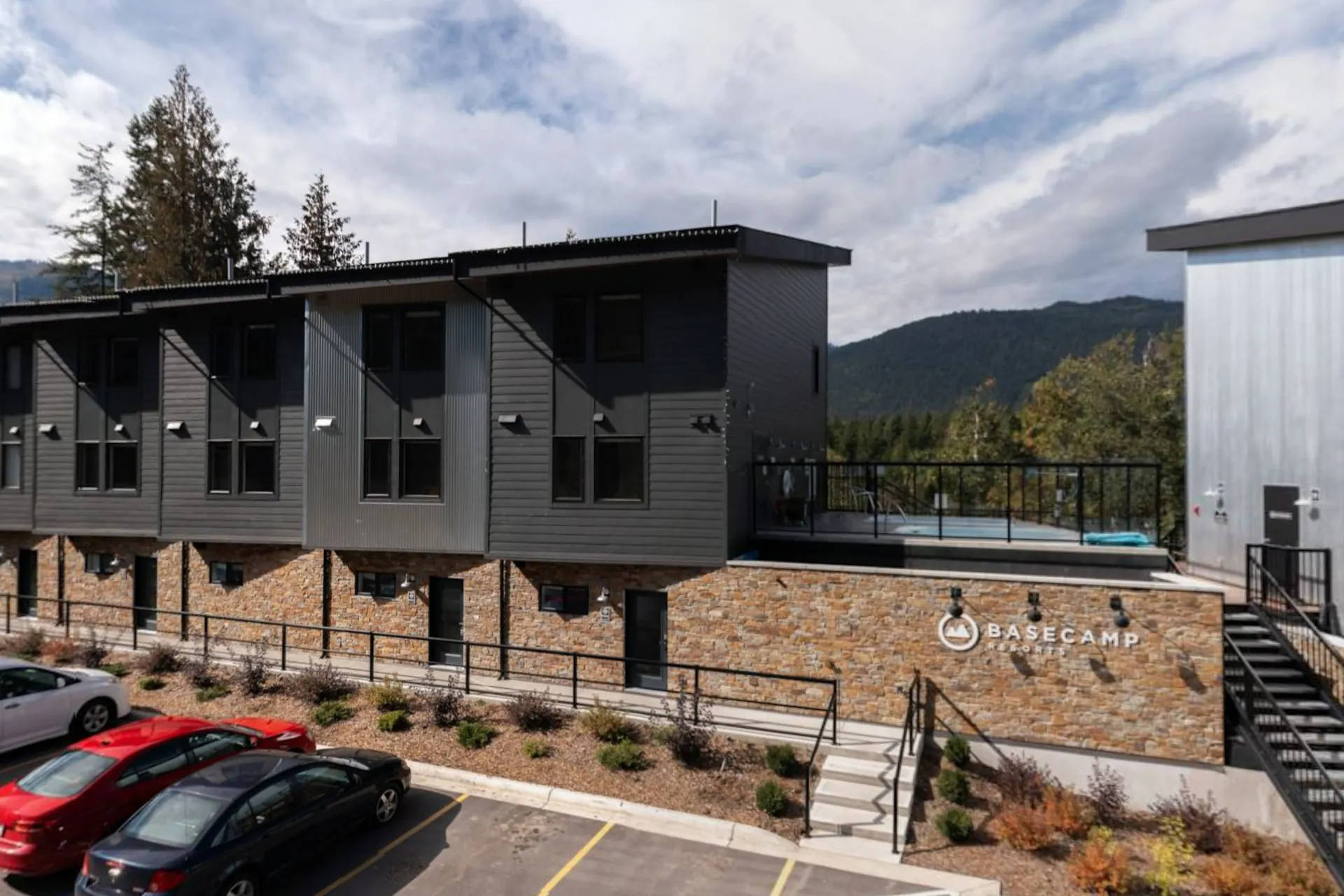 The dark-clad suites from the parking court, the rooftop hot tub deck and the Basecamp sign on the stone wall