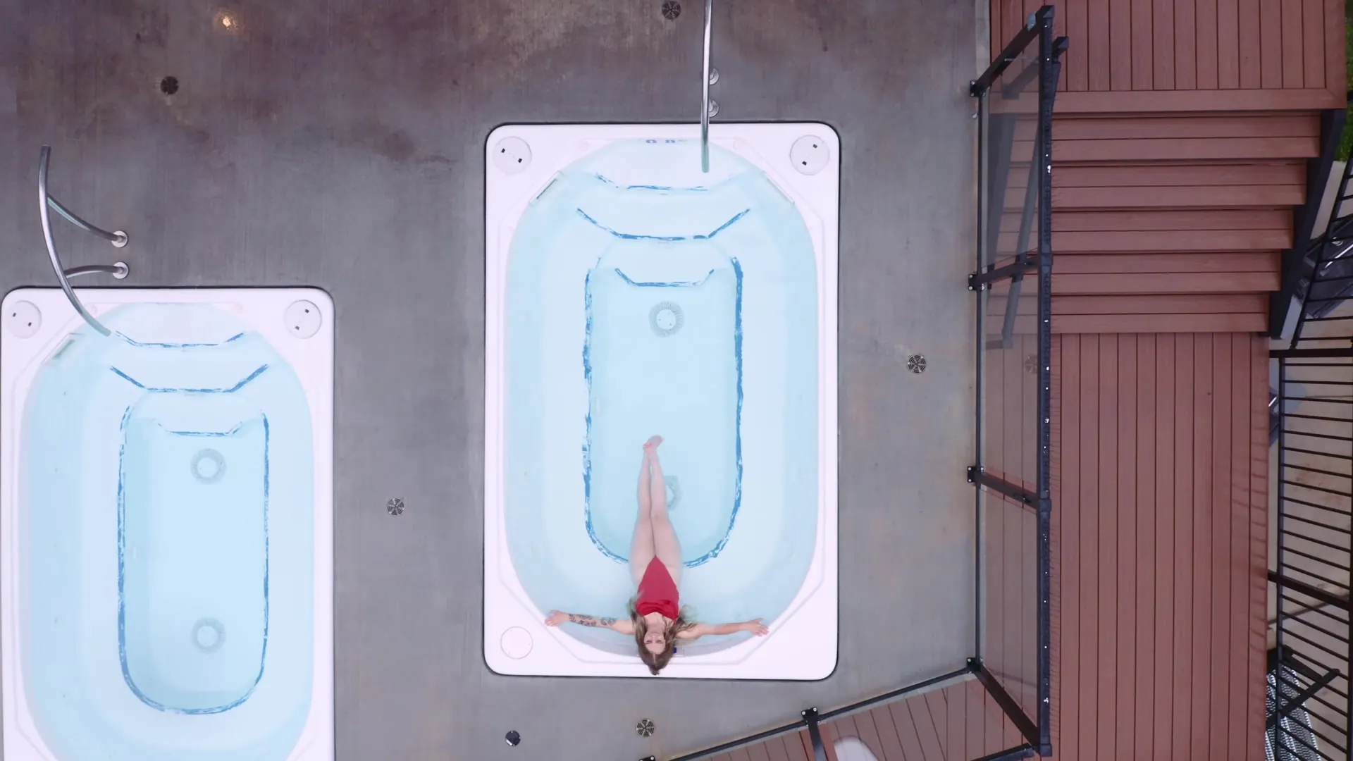 The two rooftop hot tubs seen straight down from the drone, a guest floating in one