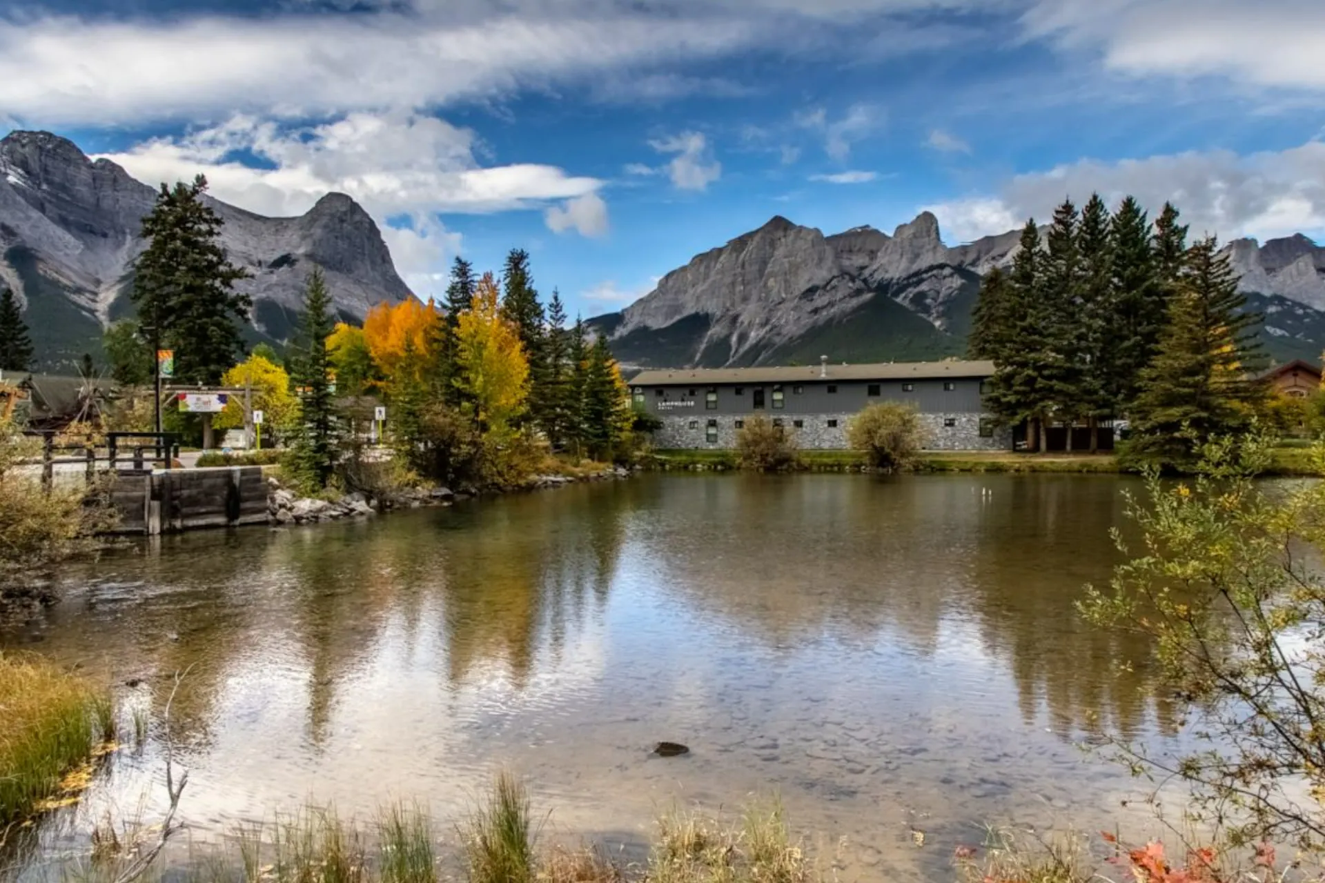 Lamphouse Hotel from across the pond on Policeman's Creek, autumn aspens and the Rundle range behind