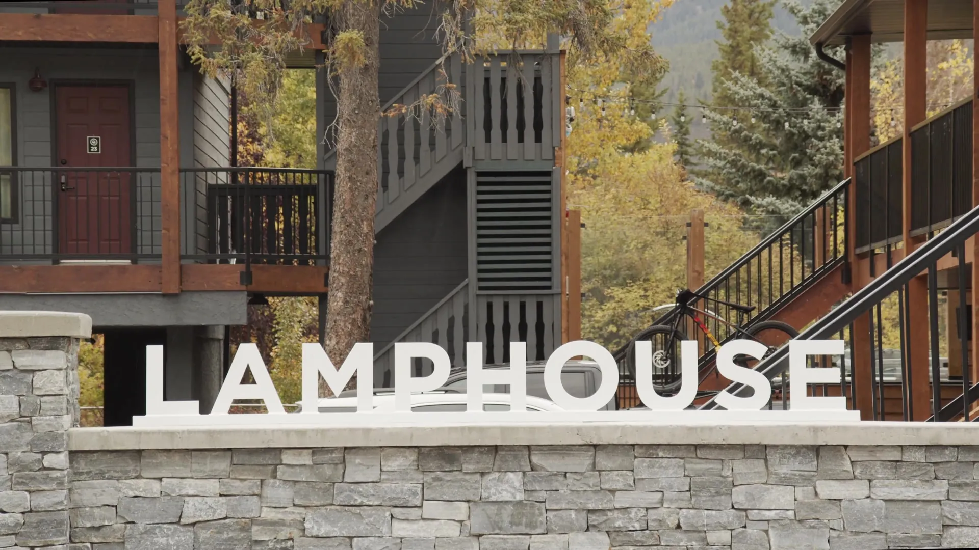 The LAMPHOUSE sign on the stone wall below the timber stairs of the motel