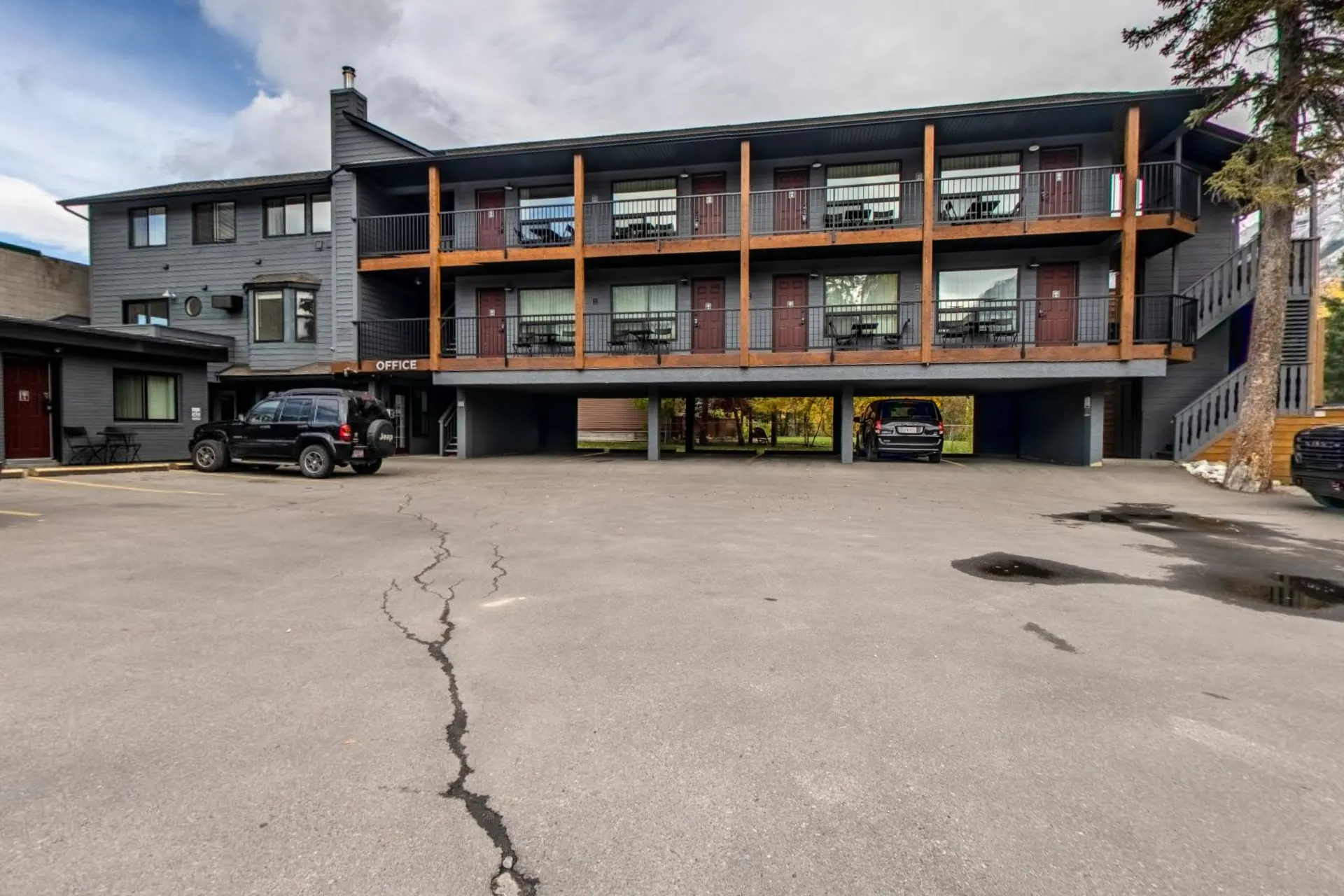 The two-storey motel building from the courtyard, timber balconies and the trees behind
