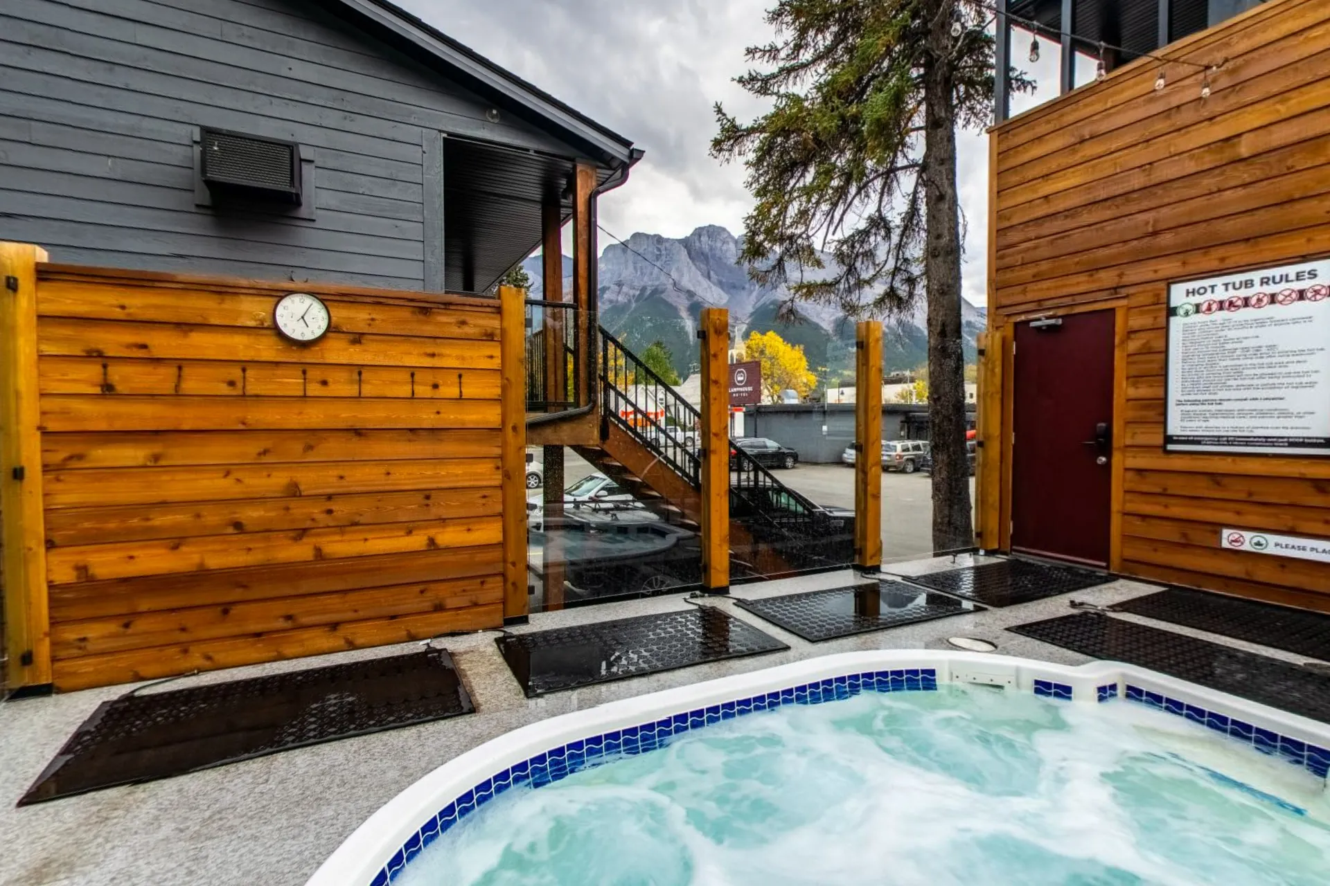 The outdoor hot tub behind a cedar screen with the mountains above