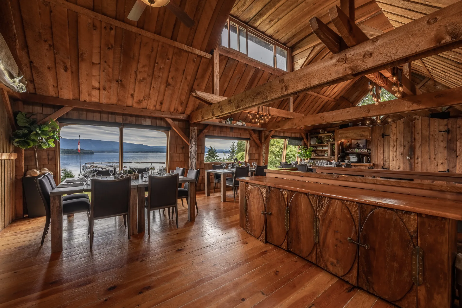 The dining room and bar under timber trusses, looking out over Broughton Strait