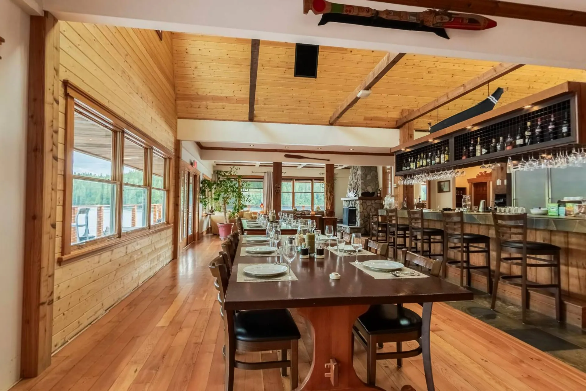 The dining room of the floating lodge, long tables set for dinner and the bar along the back wall