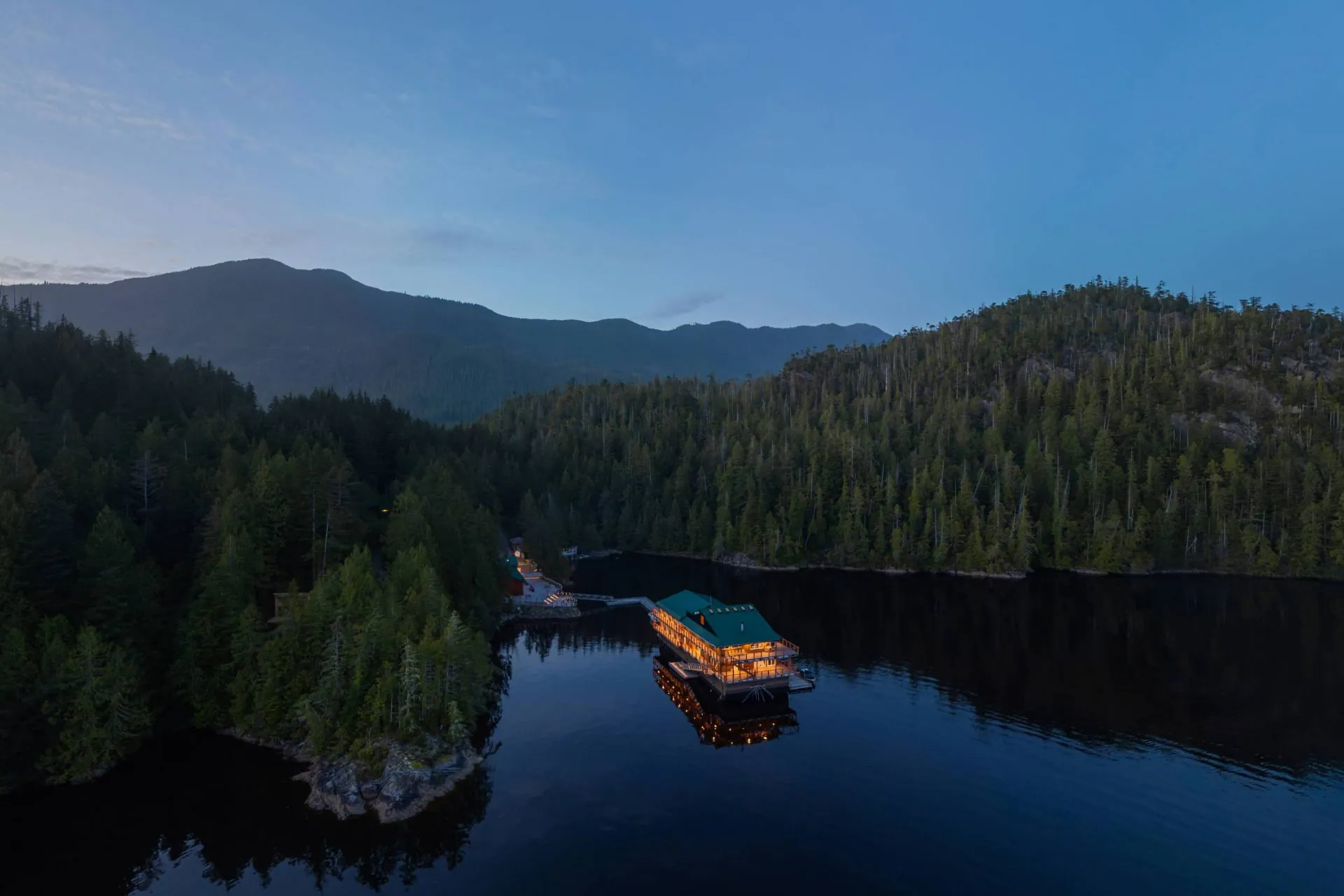 The lodge from above the bay at evening, the docks and the tree-covered point behind it