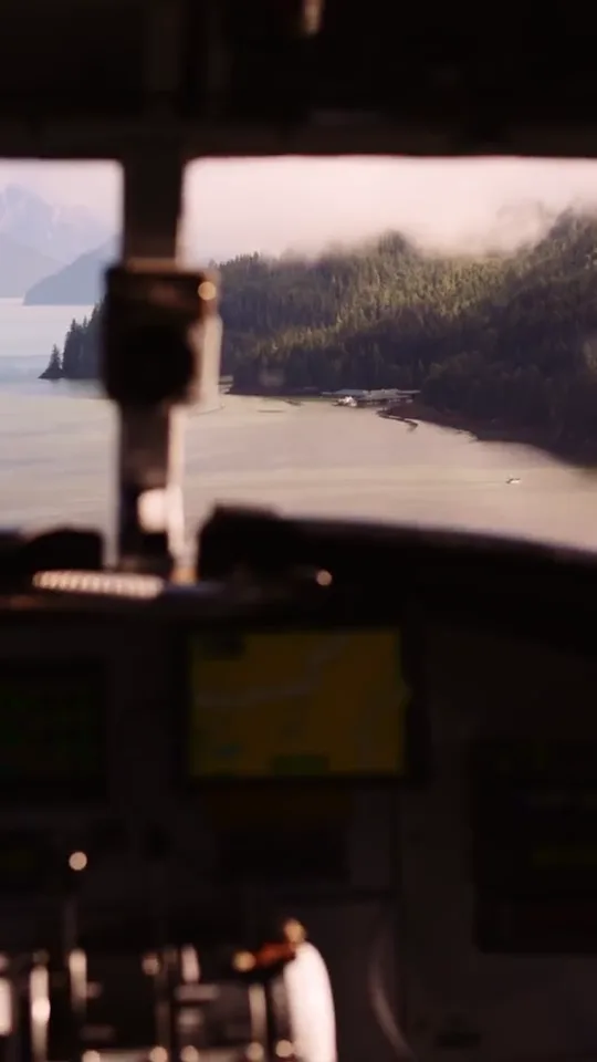 Through the floatplane cockpit on the flight in, the inlet and its forested shore ahead of the nose