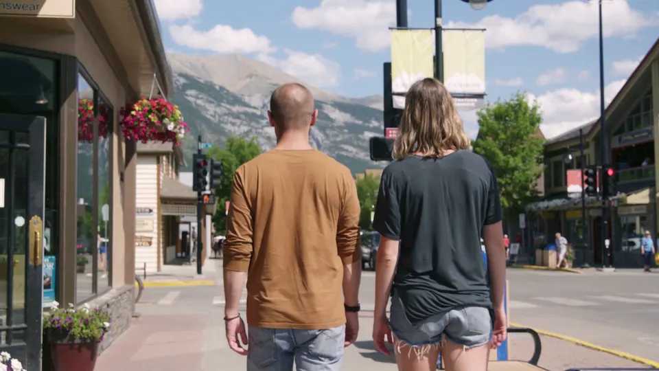 Two guests walking down Canmore's main street past the shops and flower baskets