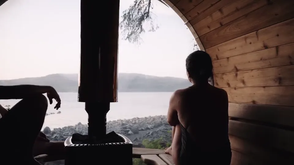 A guest on the sauna bench looking out through the porthole window at Johnstone Strait